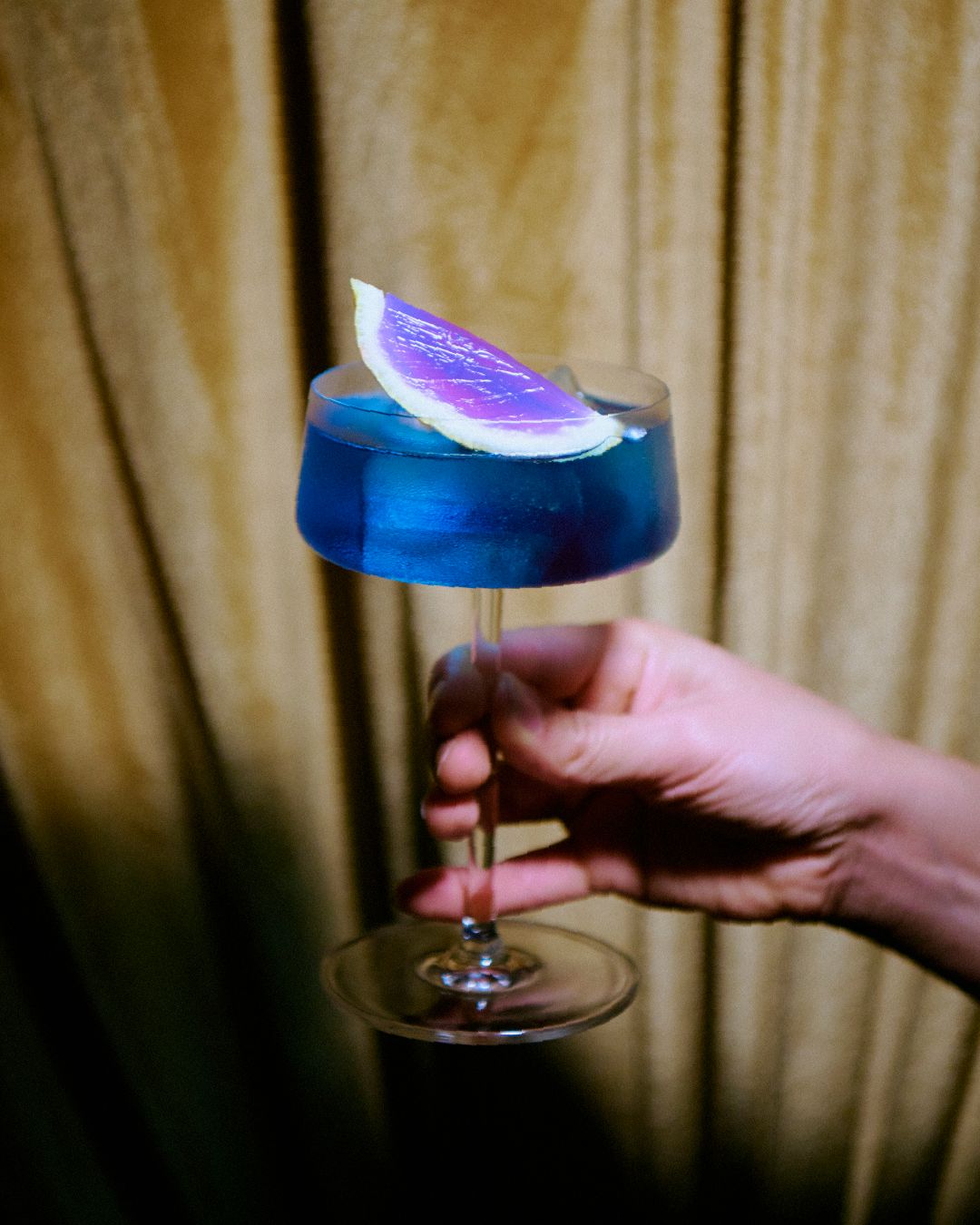 Trago azul de autor servido en copa en un cumpleaños