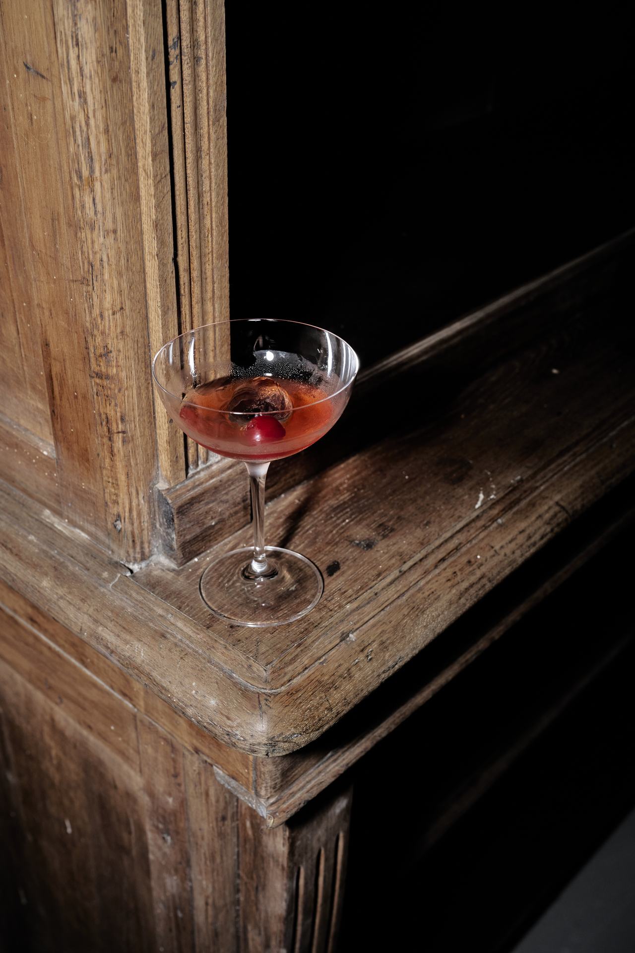 Copa coupé sobre un mueble de madera antiguo, lanzamiento Stella McCartney × H&M